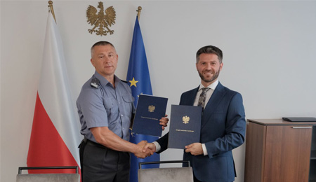 Prezes ULC oraz Szef Władzy Lotnictwa Wojskowego ściaskają sobie dłonie,  trzymają w dłoniach porozumienie. 